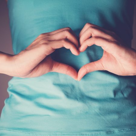 Woman hands making a heart shape on her stomach, healthy bowel degestion, probiotics  for gut health